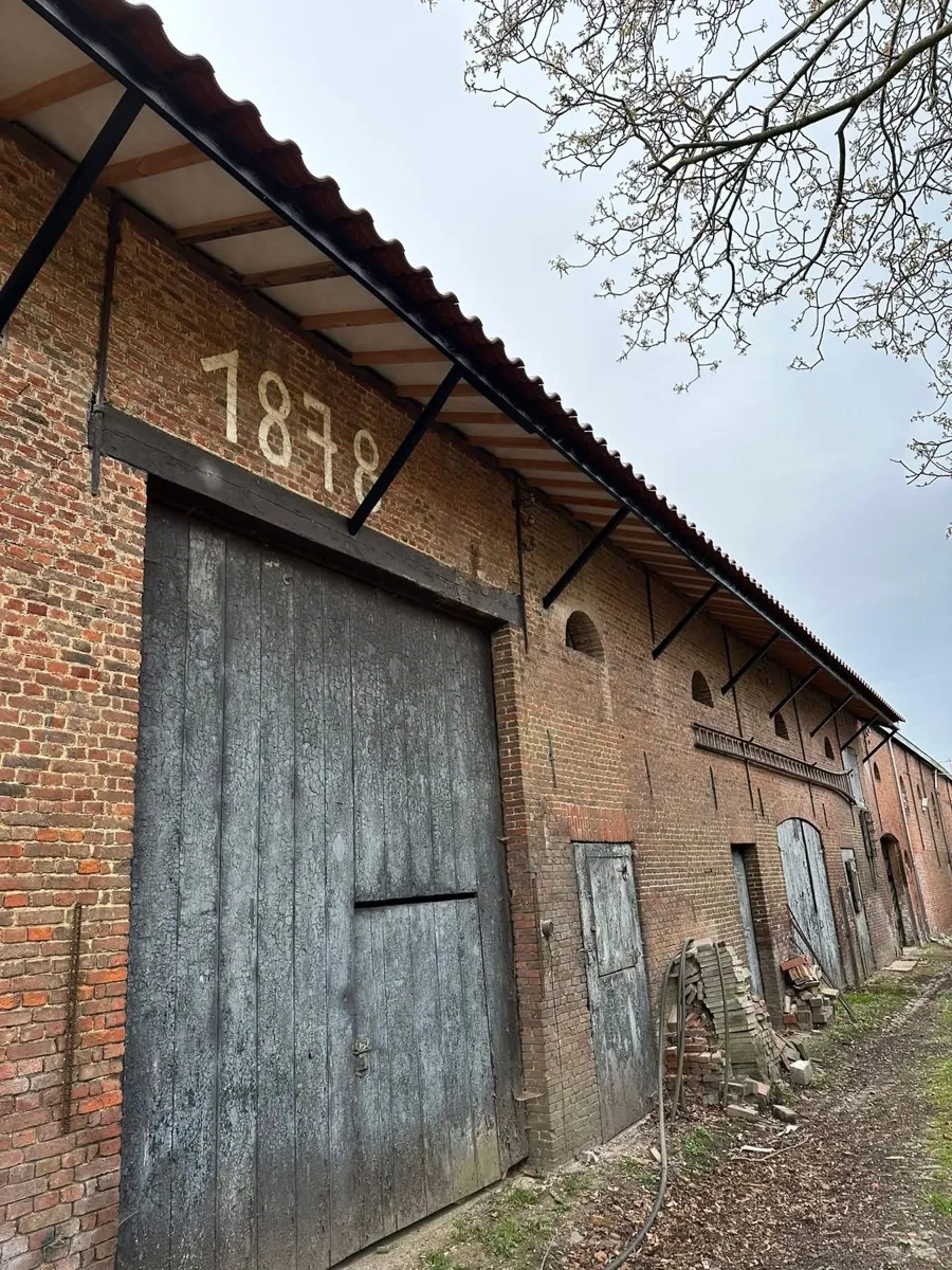 Na: nieuwe getimmerde oversteek en zinken hanggoot boven de poort uit 1878
