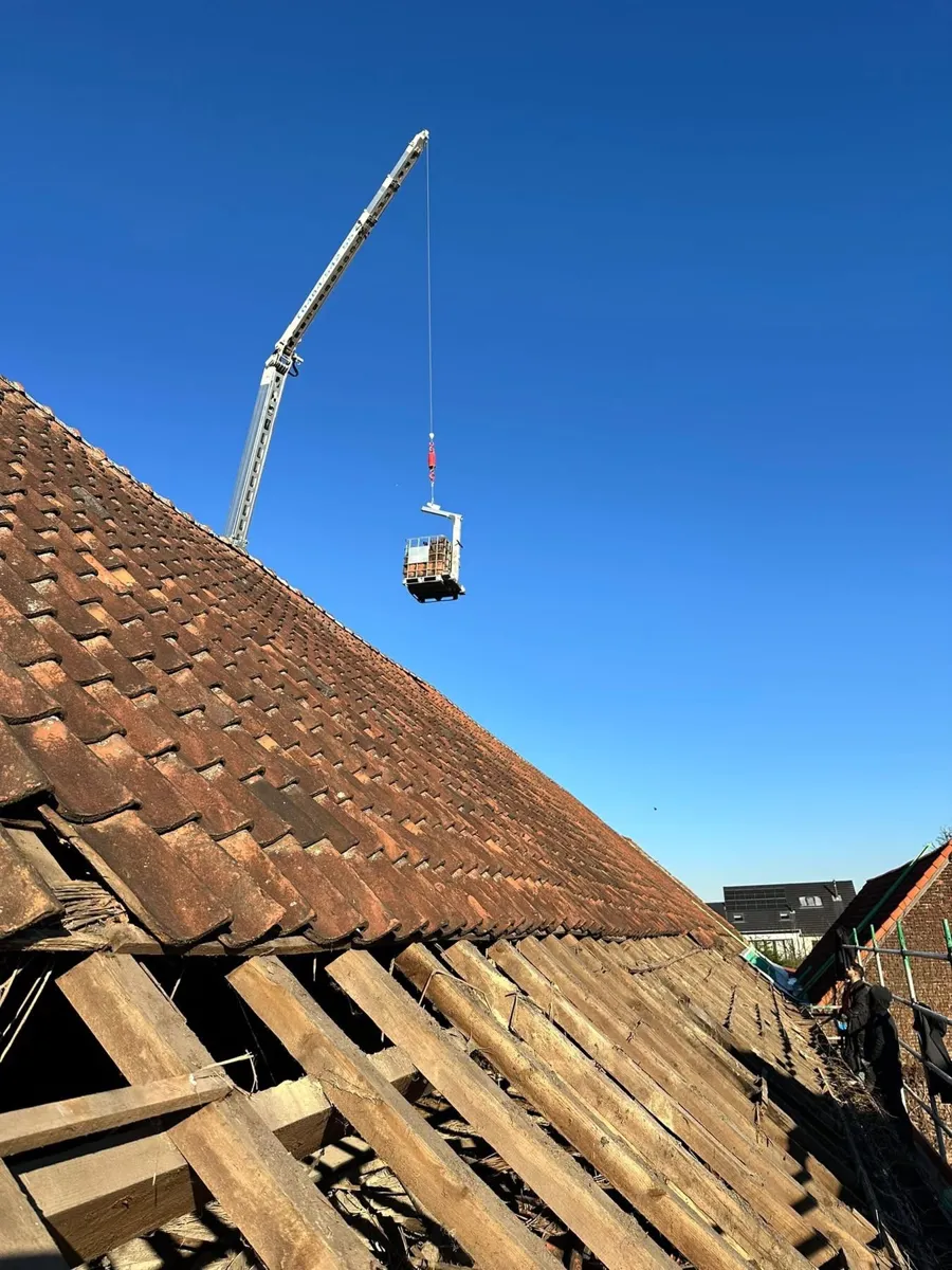Tijdens: oude pannen worden met de kraan afgevoerd
