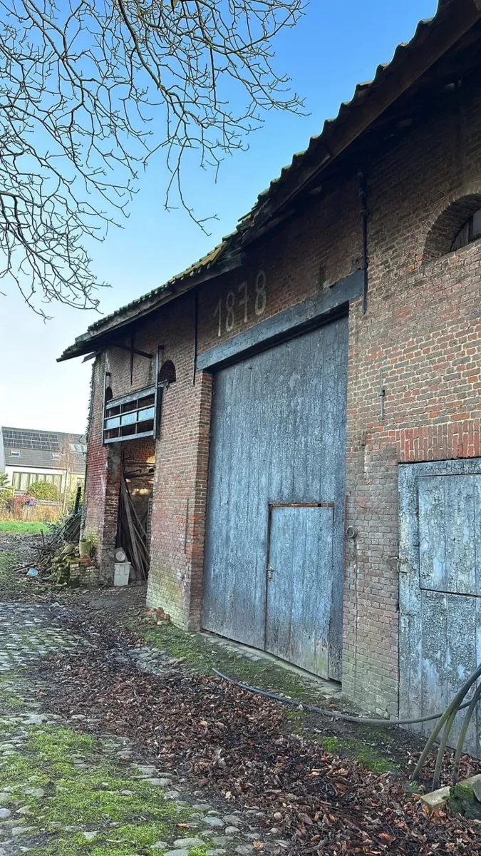 Voor: vervallen dakoversteek boven de poort met jaartal 1878