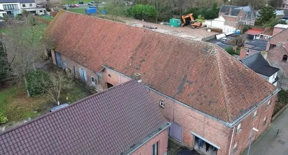 Voor: verouderd rood pannendak van de schuur uit 1878 met mos en verkleuring