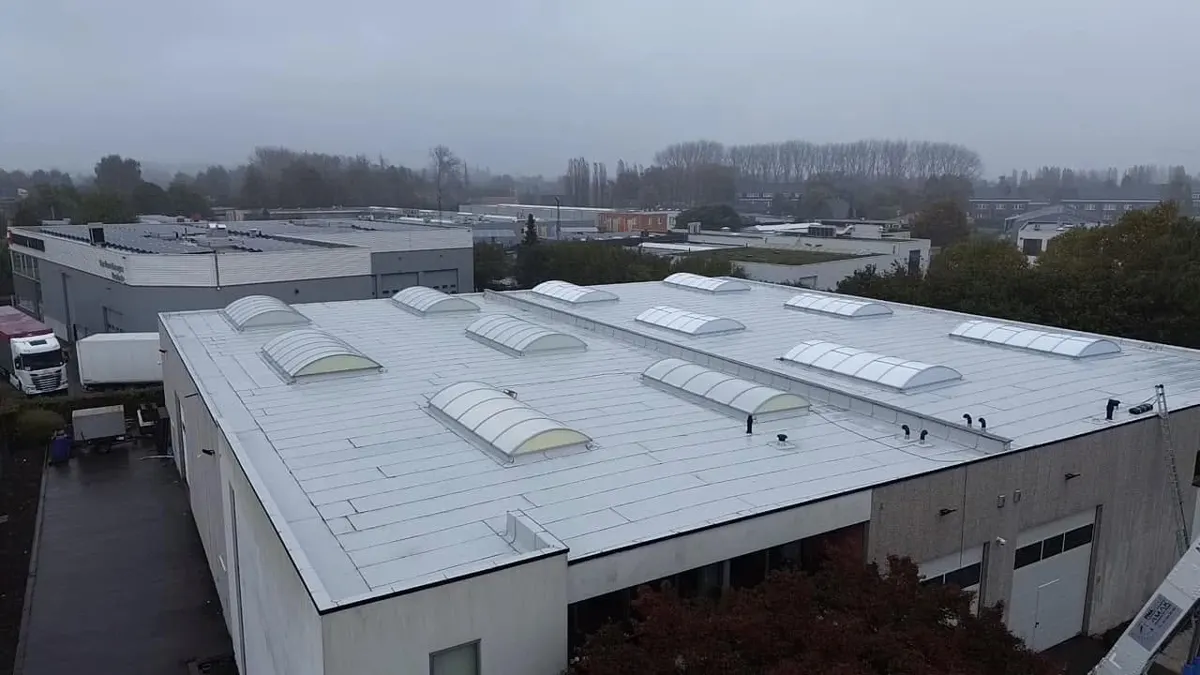 Na: volledig vernieuwd wit Soprema plat dak met lichtstraten op het magazijn in Kruibeke