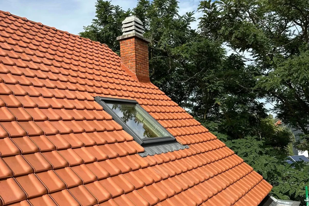 Na: nieuw Velux dakvenster en aangewerkte schouw in het rode pannendak