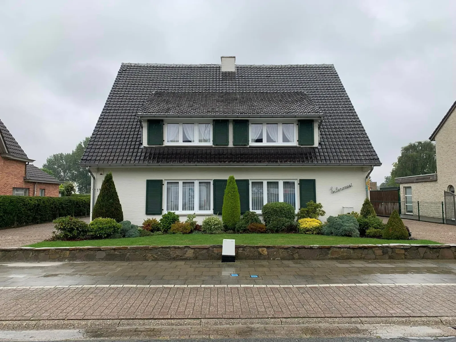 Voor: villa in Sint-Niklaas met verweerd, donker pannendak en dakkapel