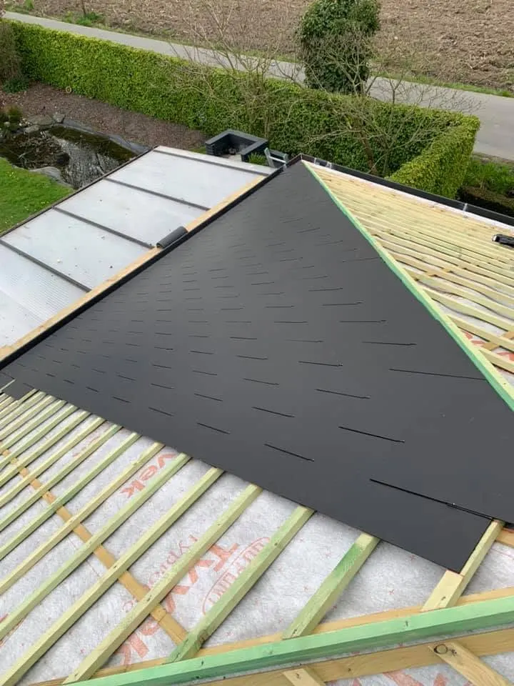 Tijdens: zwarte leien in inox haken langs de noorboom op het Tyvek-onderdak