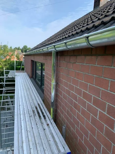 Nieuwe halfronde natuurzinken hanggoot met zinken regenpijp, gezien vanaf de stelling – dakwerk door Prodak, Temse