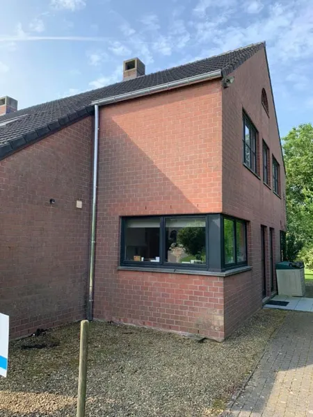 Zijgevel met nieuwe zinken hanggoot en regenpijp tot op de grond – dakwerk door Prodak, Temse
