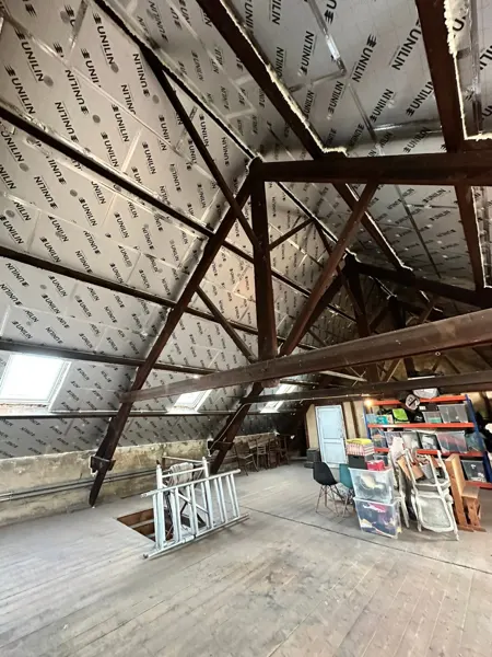 Zolder met PIR-isolatieplaten tussen en onder de houten spanten – dakwerk door Prodak, Temse