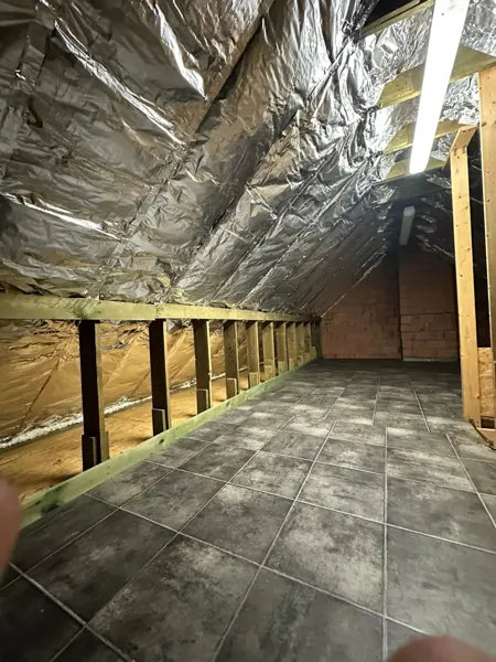 Zolder met reflecterend dampscherm langs de dakhelling en houten knieschot – dakwerk door Prodak, Temse