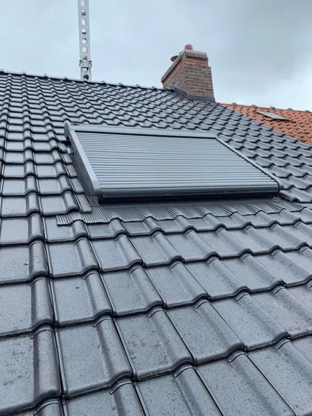 Velux-dakraam met buitenrolluik ingewerkt in een nieuw antraciet pannendak – dakwerk door Prodak, Temse