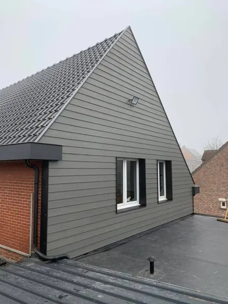 Puntgevel met sidings, dakrand en zwarte afvoer – dakwerk door Prodak, Temse