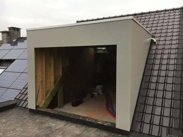 Nieuwe dakkapel met lichtgrijze gevelplaten en dakrand op een donker pannendak, vooraanzicht – dakwerk door Prodak, Temse